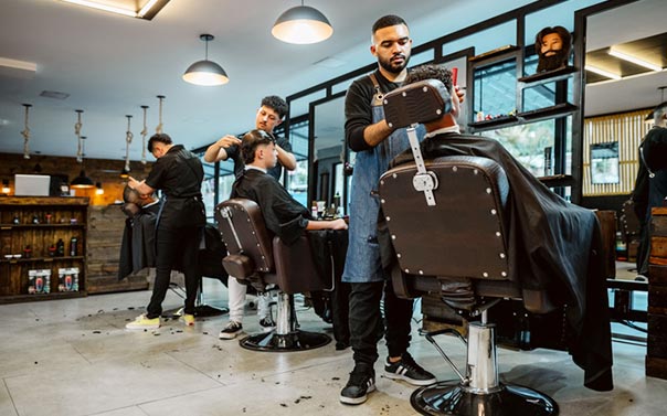 three barbers cutting hair for their clients